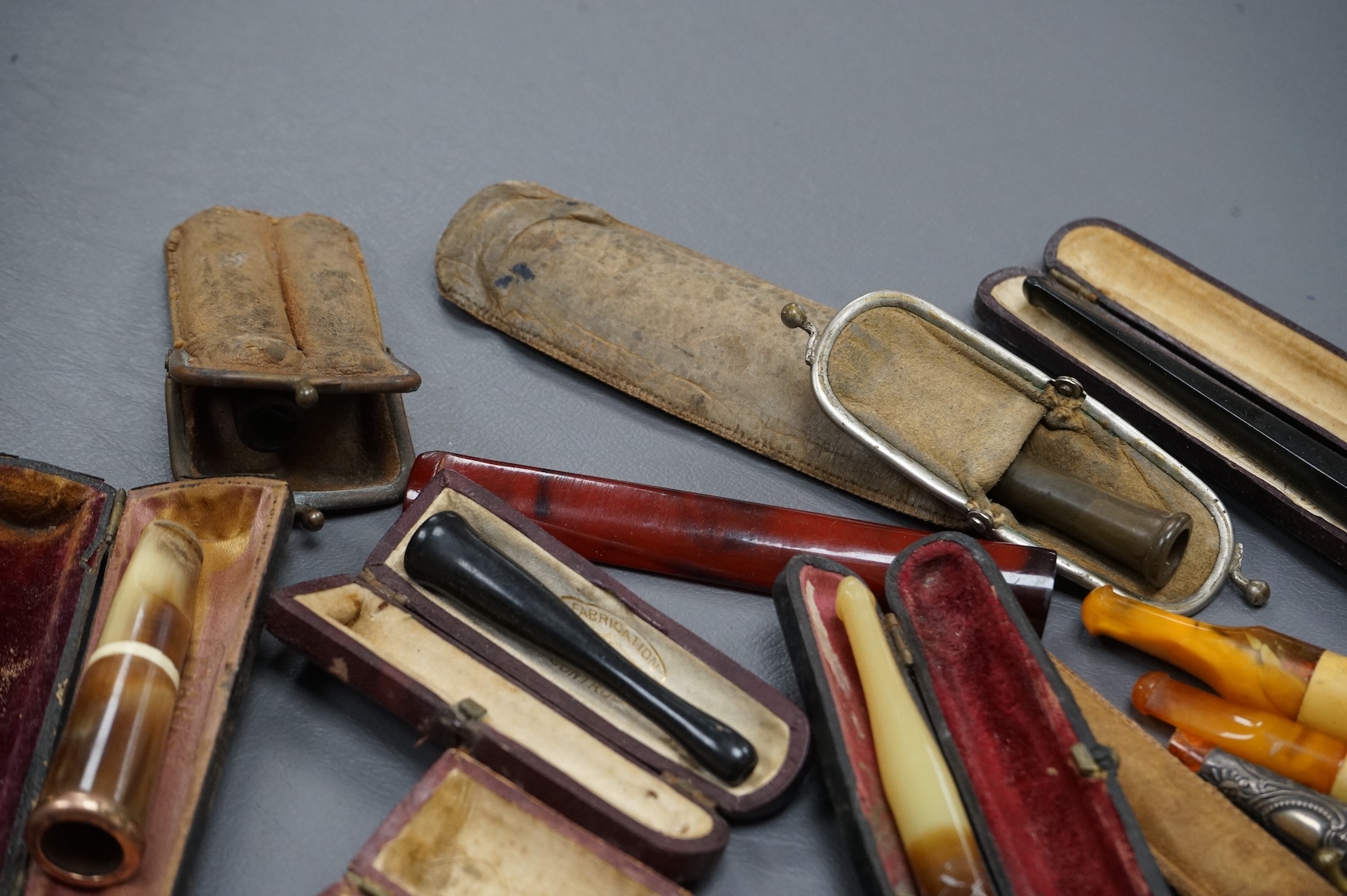 Twelve mixed cigarette and cheroot holders, some Cherry Amber, some with original cases